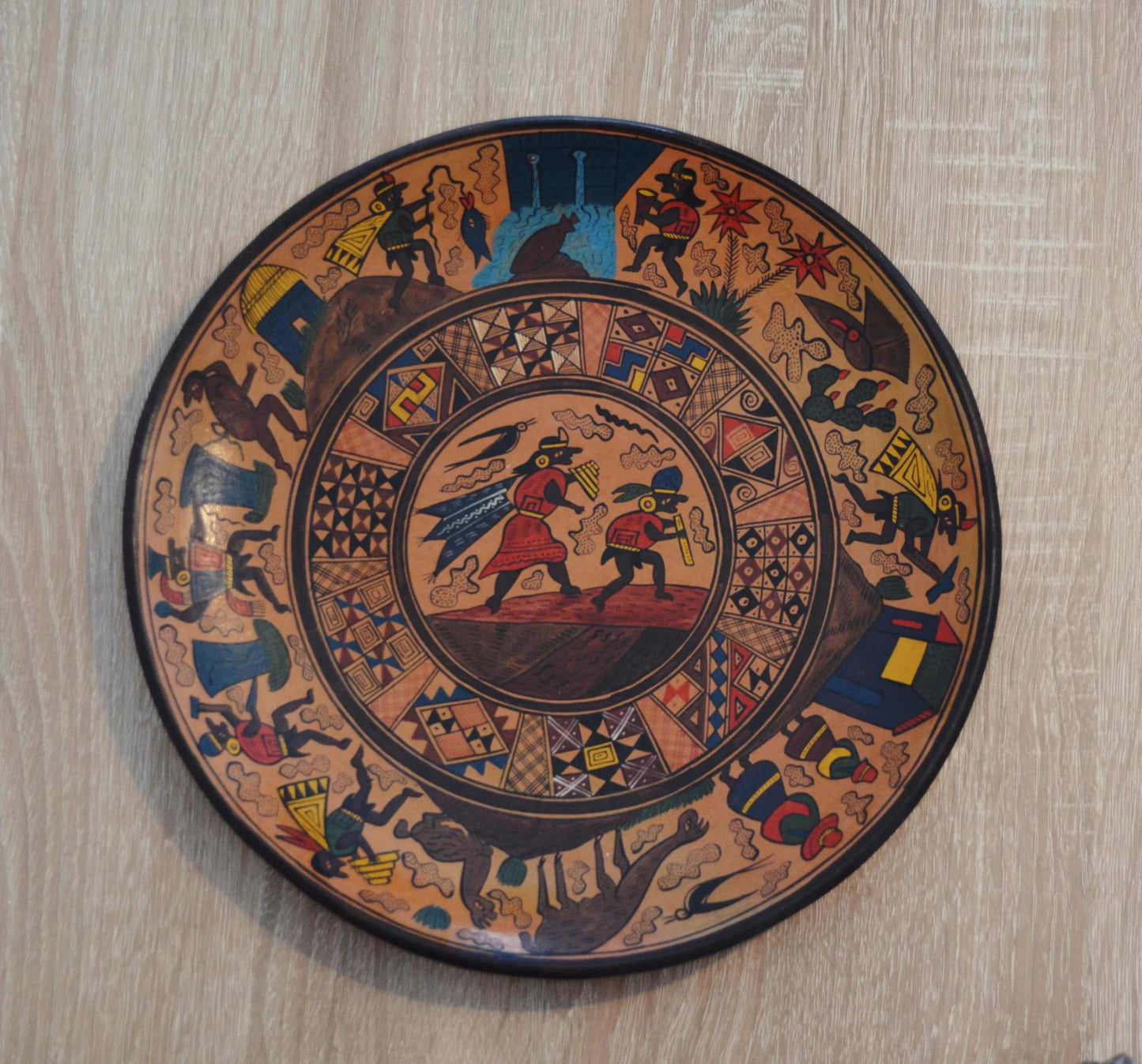Handmade Peruvian terracotta ceramic plate with colorful alpaca and traditional Andean designs.