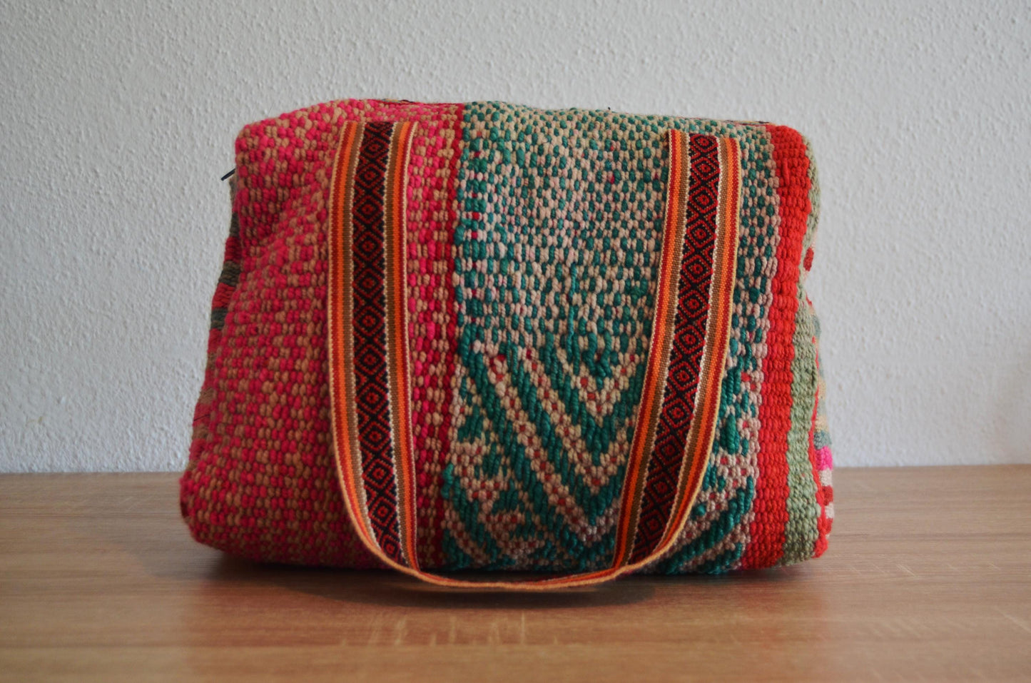 Handmade alpaca wool shoulder bag with colorful geometric patterns and striped handles.