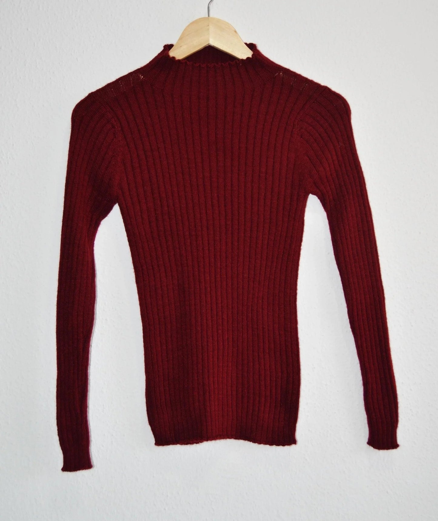 Handmade deep red alpaca turtleneck sweater with ribbed knit texture.