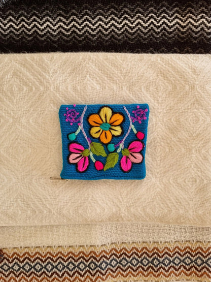 Handmade blue alpaca wool wallet with vibrant floral embroidery and compact design.
