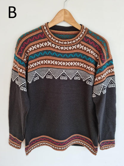 Handmade alpaca sweater with multicolor geometric patterns and solid dark base.