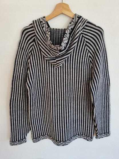 Handmade black and white striped alpaca wool sweater with hood and long sleeves.