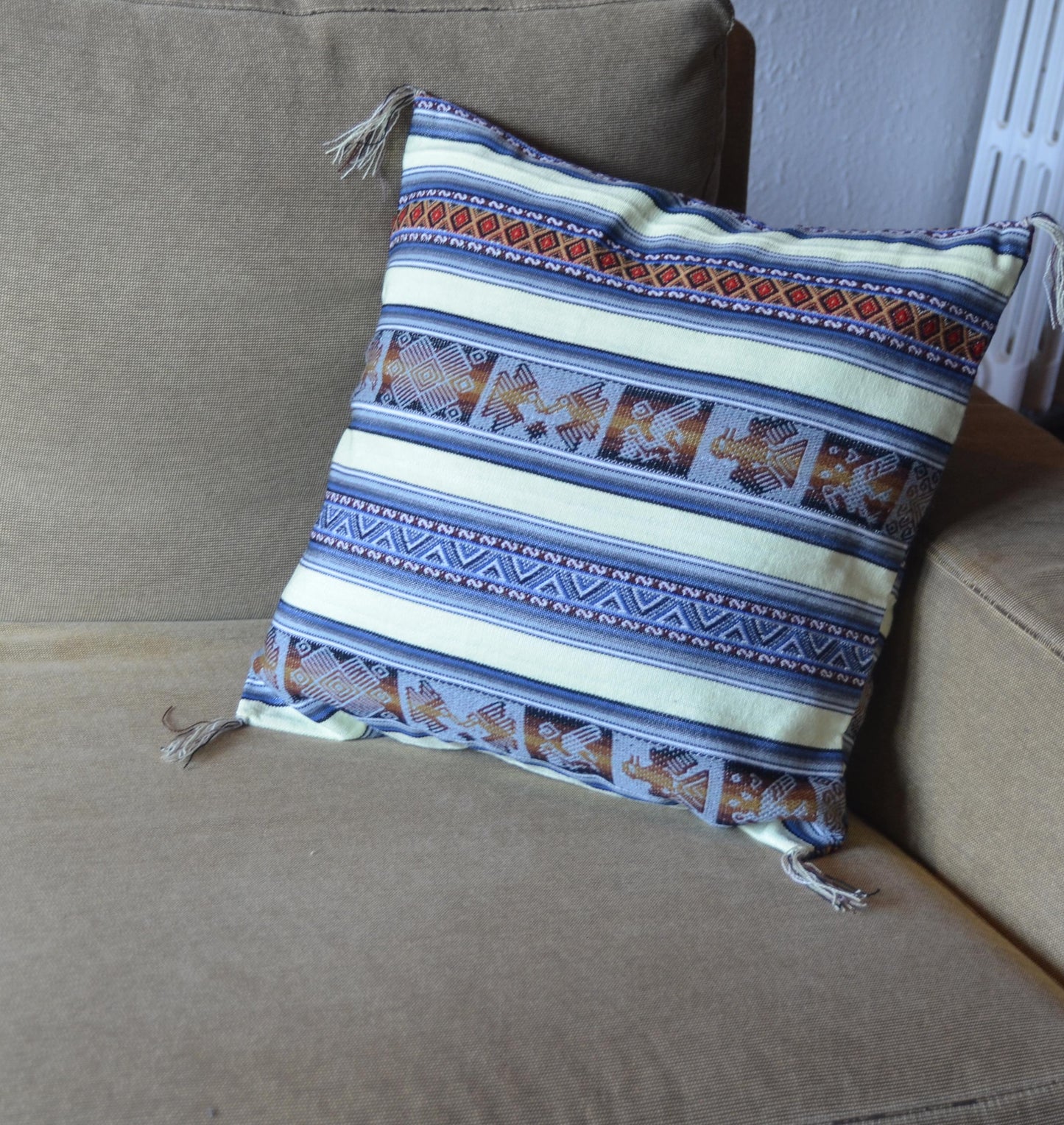 Handmade Peruvian pillow with alpaca motifs in blue, white, and orange woven stripes.