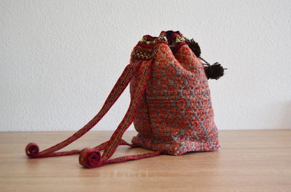 Handmade alpaca shoulder bag with colorful traditional Peruvian pattern and drawstring closure.