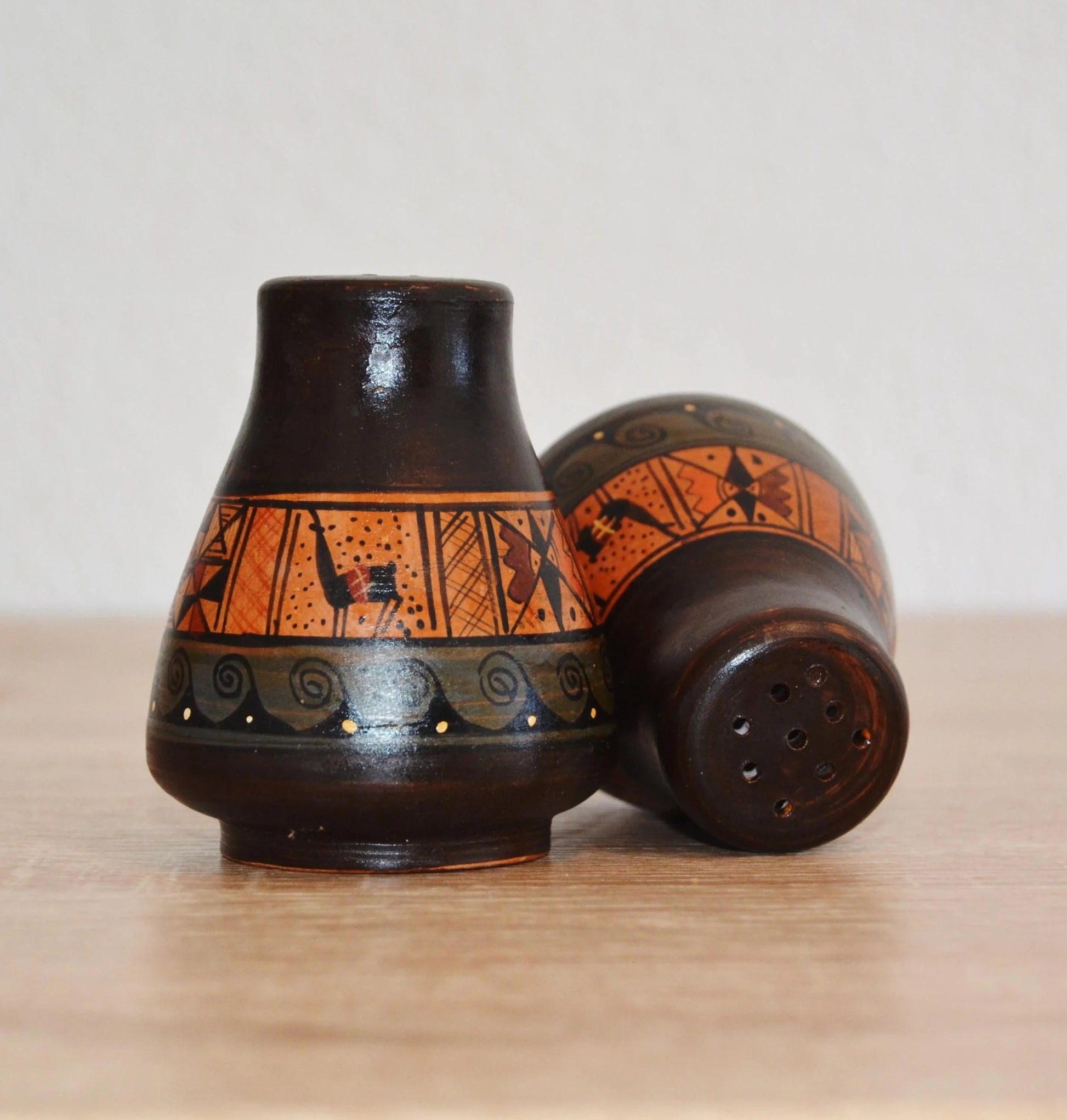 Handmade Peruvian terracotta jug with black and orange alpaca motif and rustic finish.