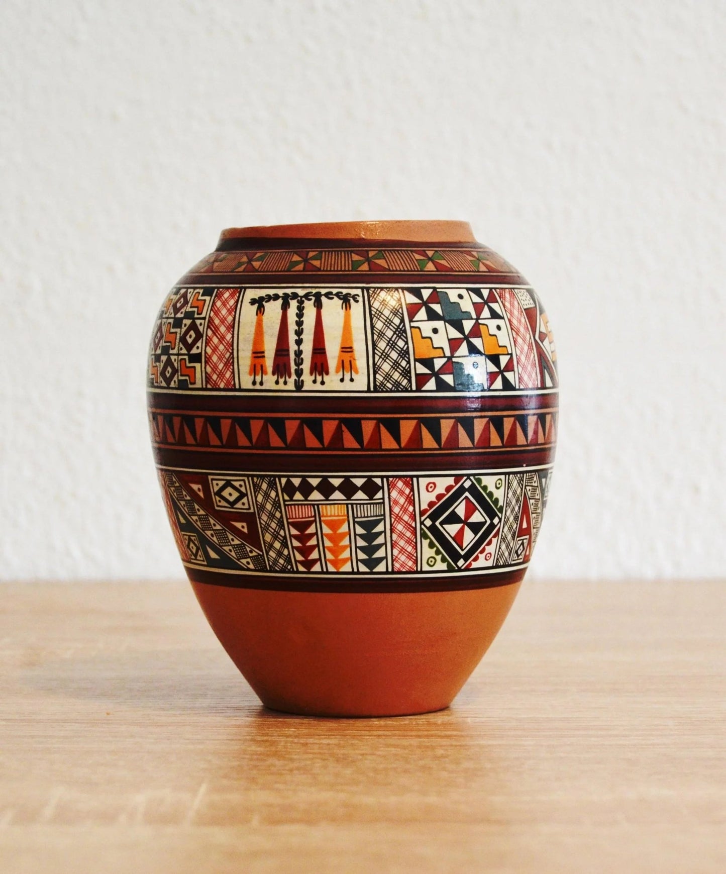 Handmade terracotta jar with intricate traditional Andean patterns and alpaca motifs.