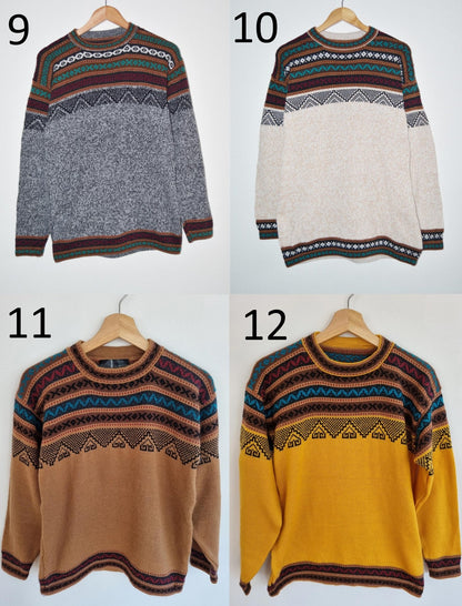 Four handmade alpaca sweaters with colorful patterned yokes in gray, off-white, camel, and mustard yellow colors.