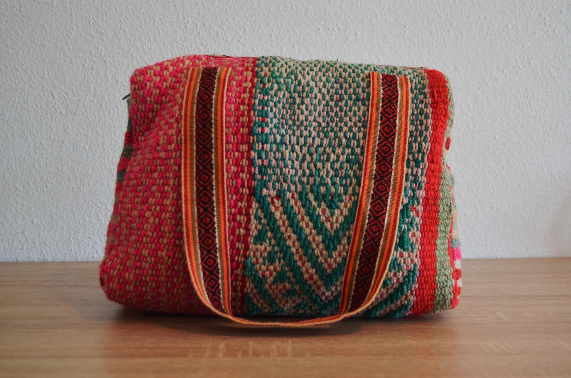 Handmade alpaca wool shoulder bag with colorful geometric patterns and striped handles.