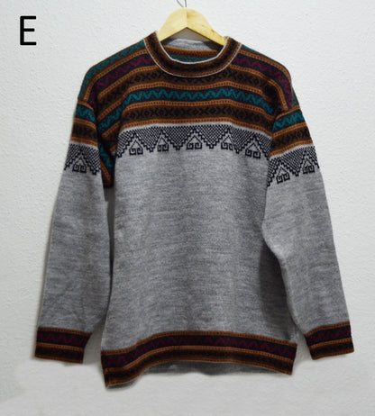 Handmade alpaca sweater with gray base and colorful geometric patterns on yoke and cuffs.