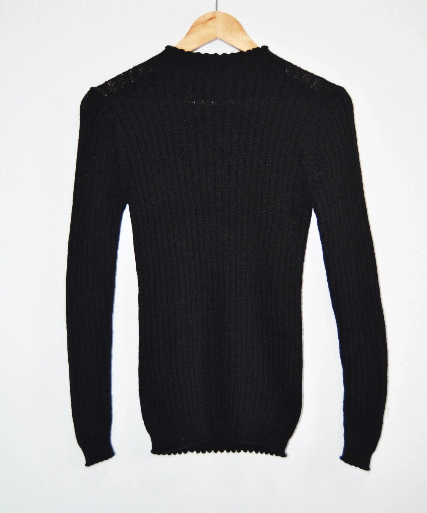 Black handmade alpaca turtleneck sweater with ribbed knit and long sleeves.