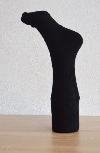Black handmade alpaca and cotton sock with ribbed texture, mid-calf length.