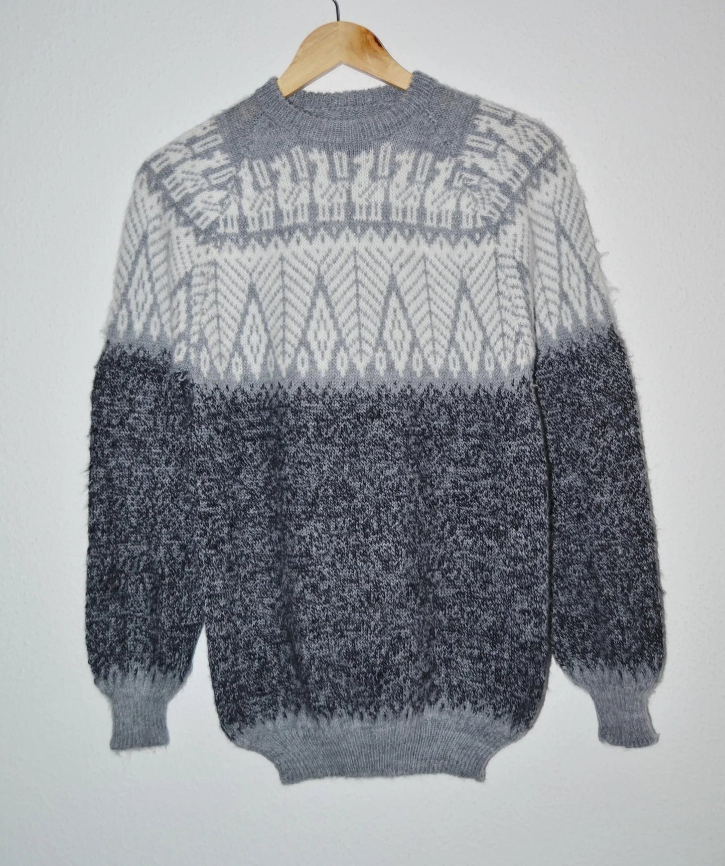 Handmade alpaca sweater in gray and black with geometric patterns and ribbed cuffs.