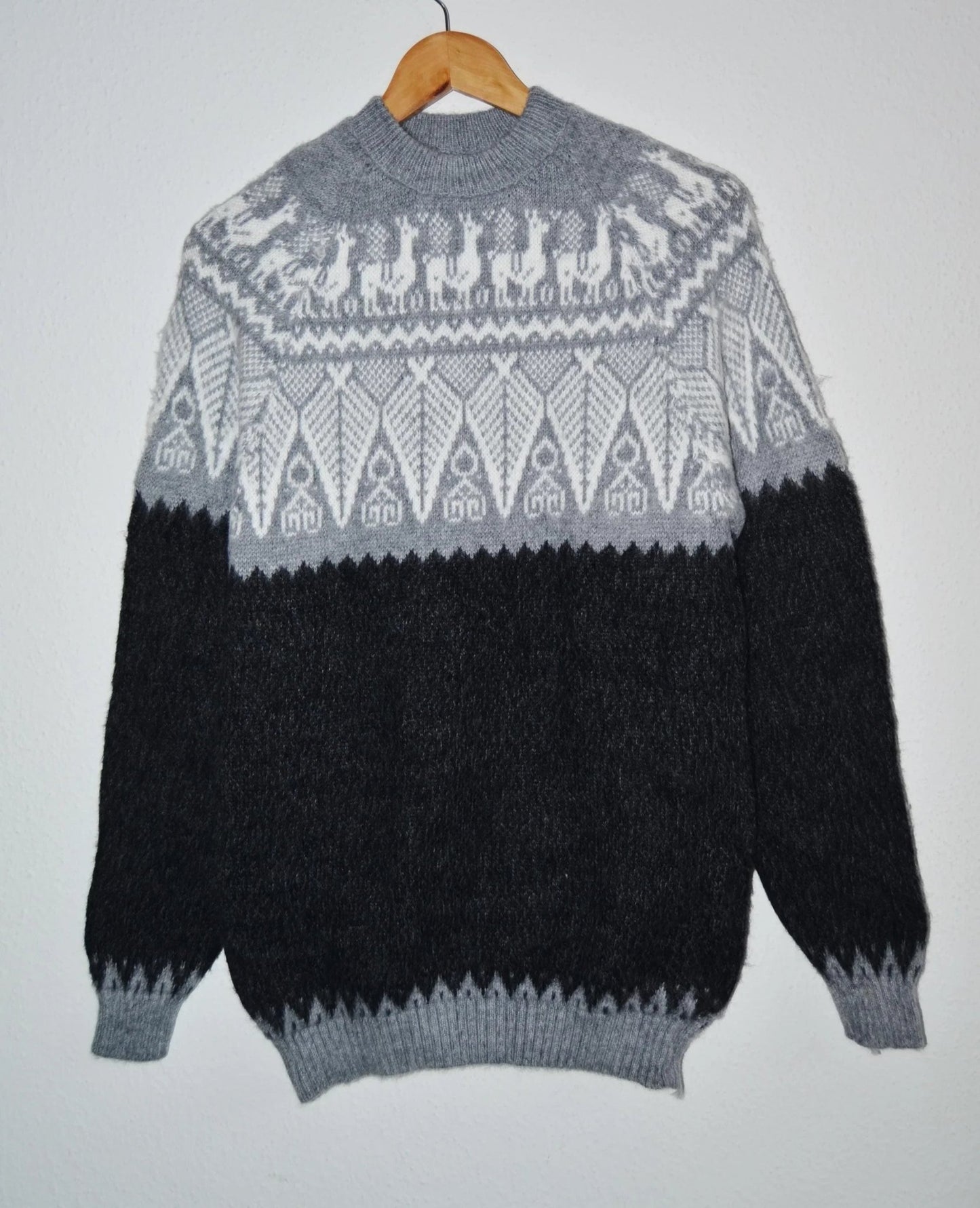Handmade alpaca sweater with gray and black color blocking and geometric patterns.