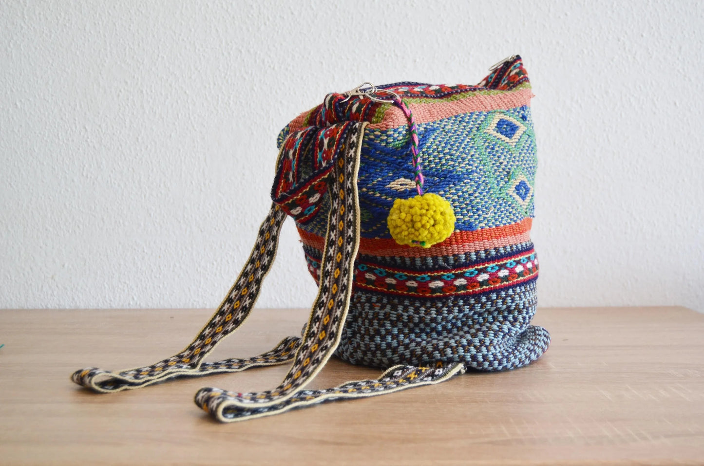 Colorful handmade alpaca shoulder bag with intricate geometric patterns and woven strap.