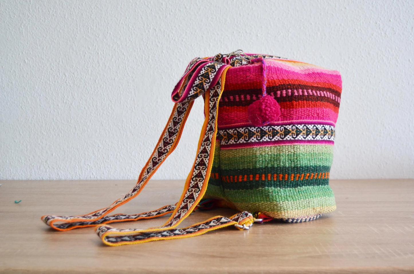 Handmade colorful alpaca shoulder bag with traditional Peruvian patterns and woven strap.