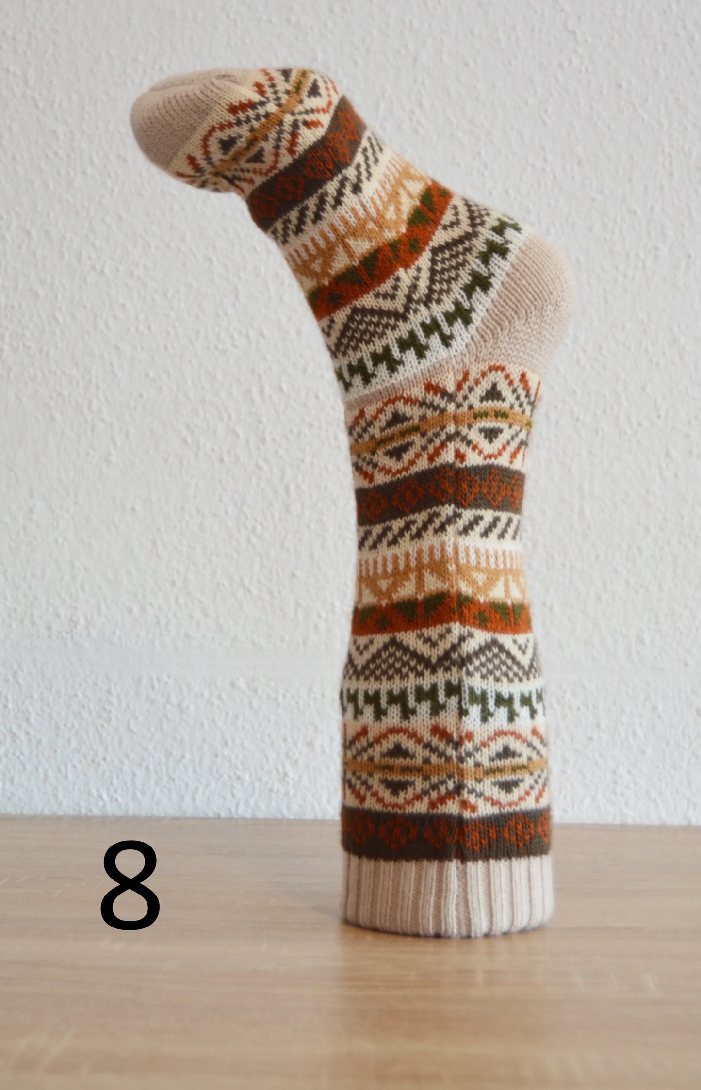 Handmade alpaca wool sock with geometric patterns in brown, orange, and cream tones.