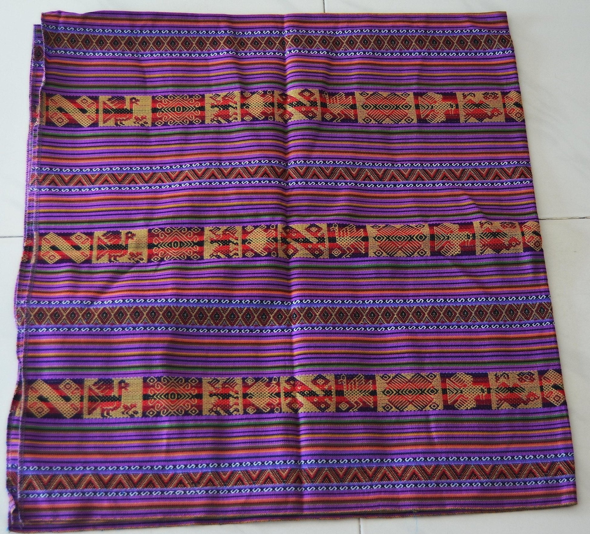Handmade alpaca blend mestana cloth with vibrant purple, red, and orange Andean geometric patterns.