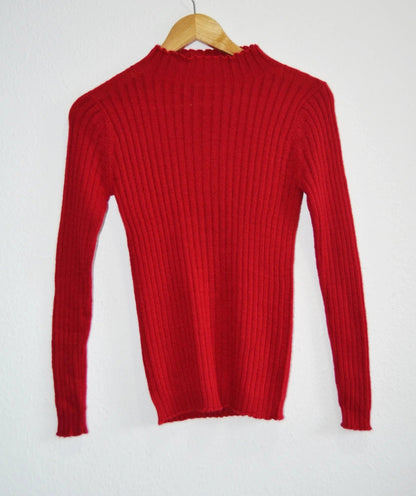 Red handmade alpaca turtleneck sweater with ribbed knit texture.