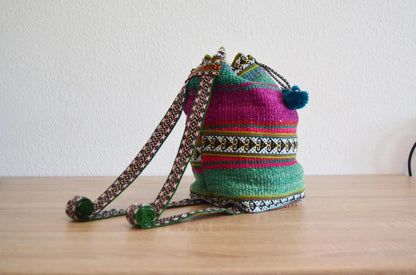 Handmade colorful alpaca shoulder bag with traditional Peruvian patterns and pom-pom details.