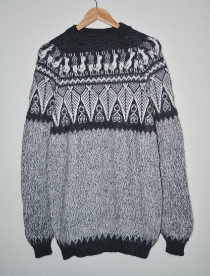 Handmade alpaca sweater in black and gray with intricate geometric and animal patterns.