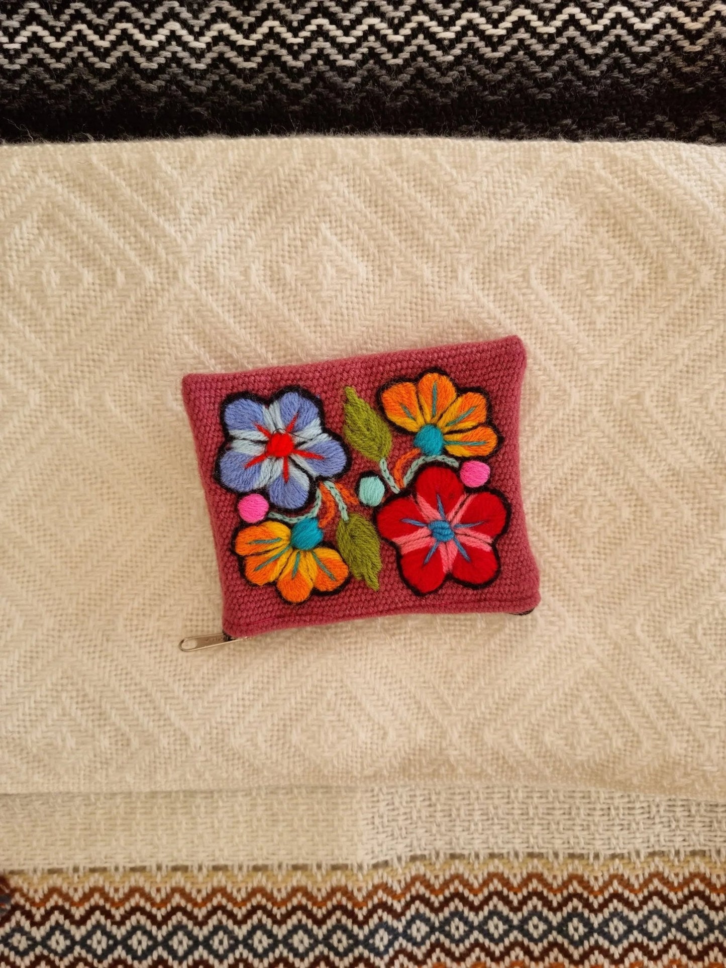 Handmade red alpaca wallet with colorful floral embroidery and compact design.
