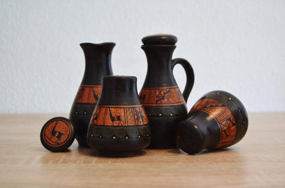 Set of handmade Peruvian terracotta pottery with black and orange alpaca motifs.