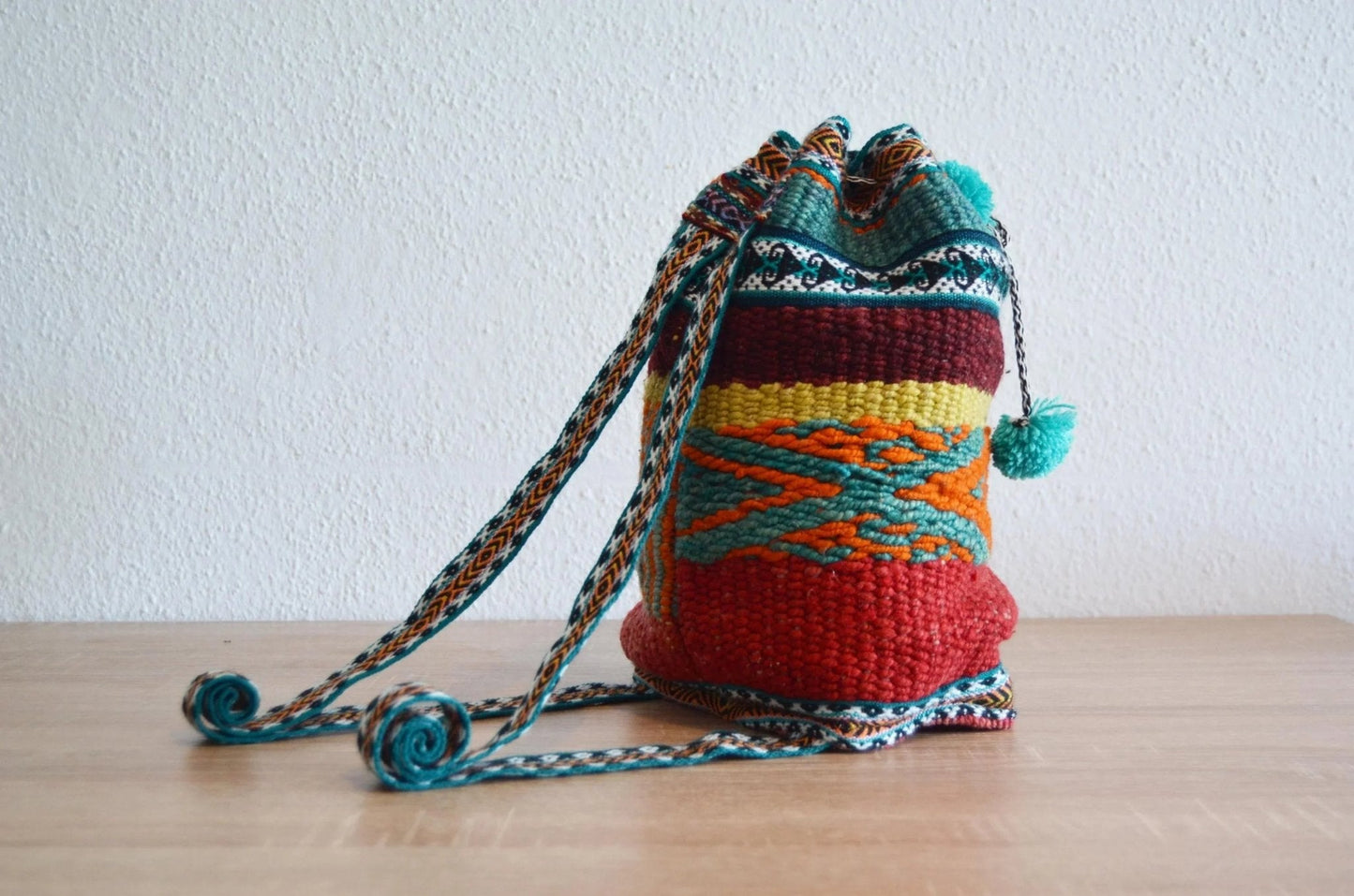 Handmade alpaca shoulder bag with colorful traditional Andean patterns and braided strap.