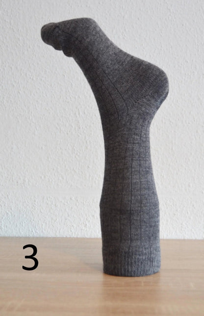 Handmade dark gray alpaca and cotton sock with ribbed texture, mid-calf length.