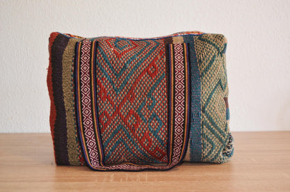 Handmade alpaca wool shoulder bag with red and green geometric patterns and bold vertical stripes.