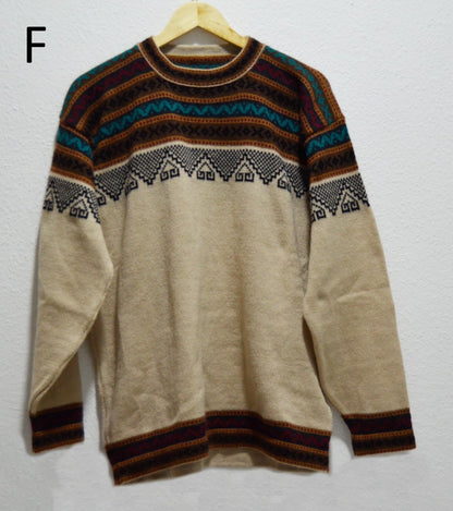 Handmade alpaca sweater with beige base and multicolor geometric patterns on yoke and cuffs.